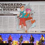 Escenario del Palacio de Congresos de Huesca con los ponentes de la mesa de debate sobre información en TikTok