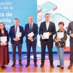 Seis personas posan en el escenario durante la presentación del número 84 de la Revista de Economía Aragonesa, organizada por Ibercaja. Cada una sostiene un ejemplar de la revista frente a un fondo azul con el nombre del evento.